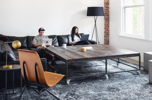 People working on their laptops, sitting in a lounge area.